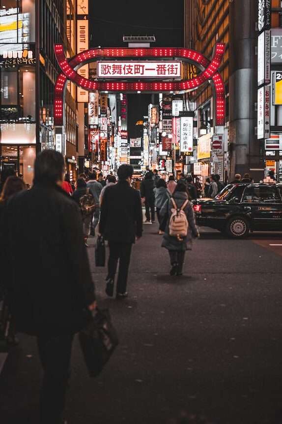 people walking down street of kabukicho at night