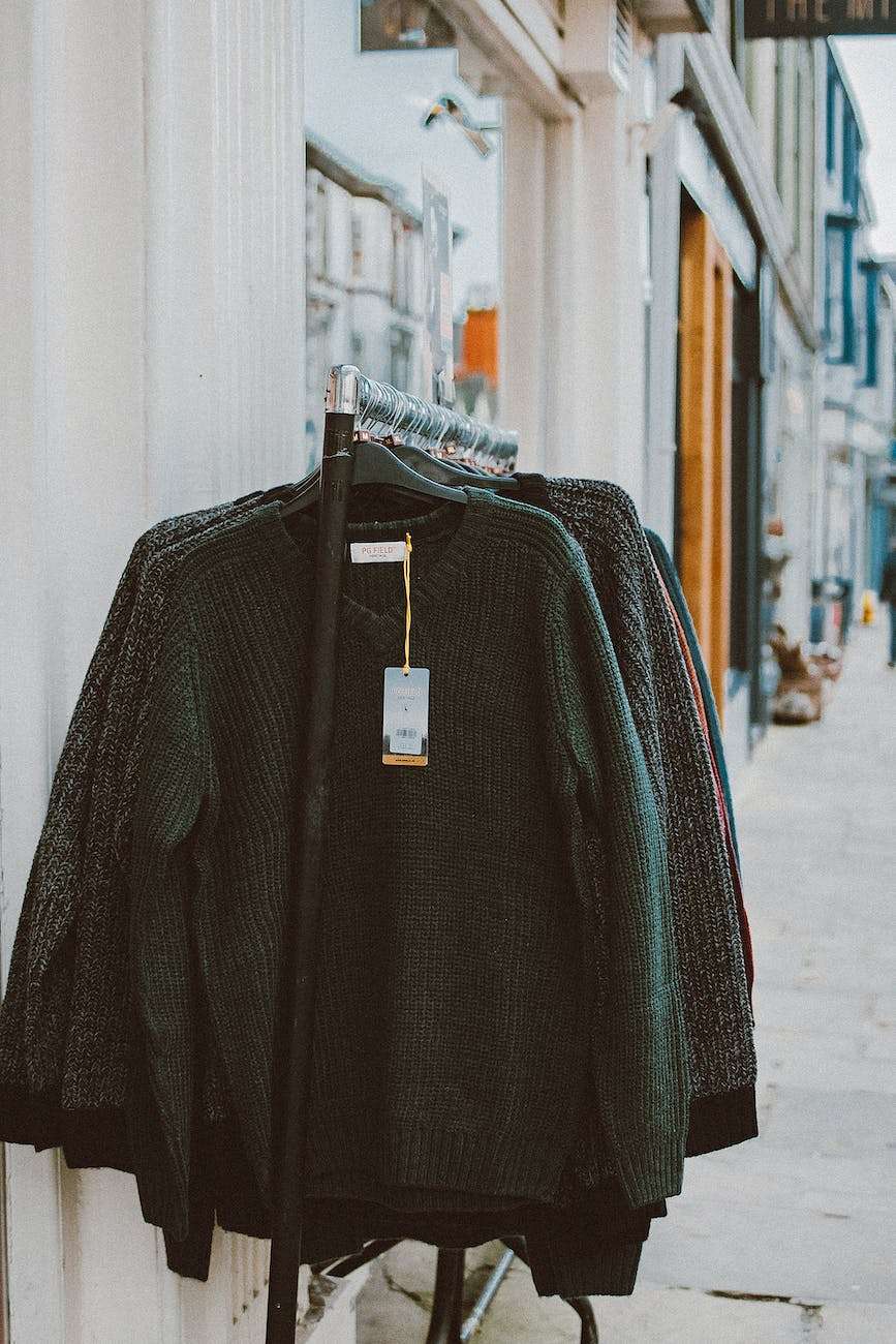 assorted clothes hanging on a rack outside store